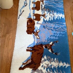Vintage handmade latch-hook rug featuring a winter scene with deer.